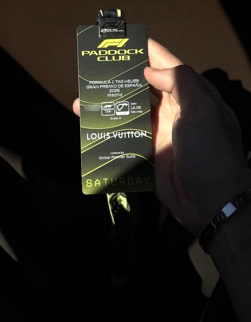 A hand holding a Formula 1 Paddock Club pass for the Spanish Grand Prix in Madrid, lit by a shaft of sunlight